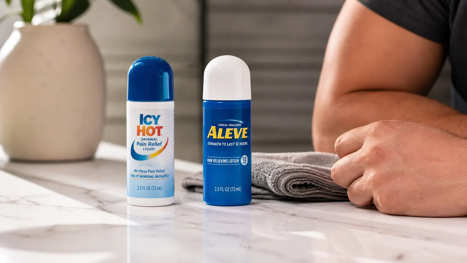 Two topical pain relief products side by side on a gym bag with a rolled towel in background