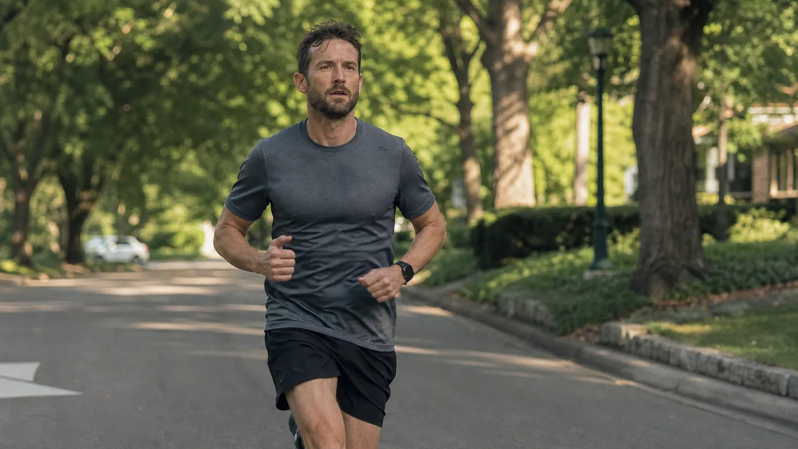 Runner on a track looking fatigued, sitting and stretching legs before using recovery gear